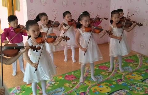 Children aged 4 to 6 paying violins