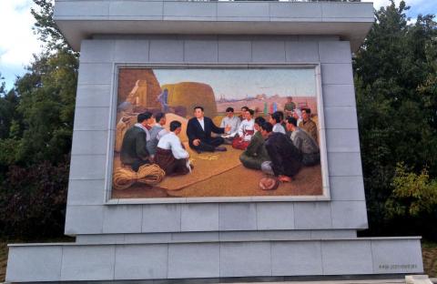 Mosaic of "Dear Leader" instructing farm workers